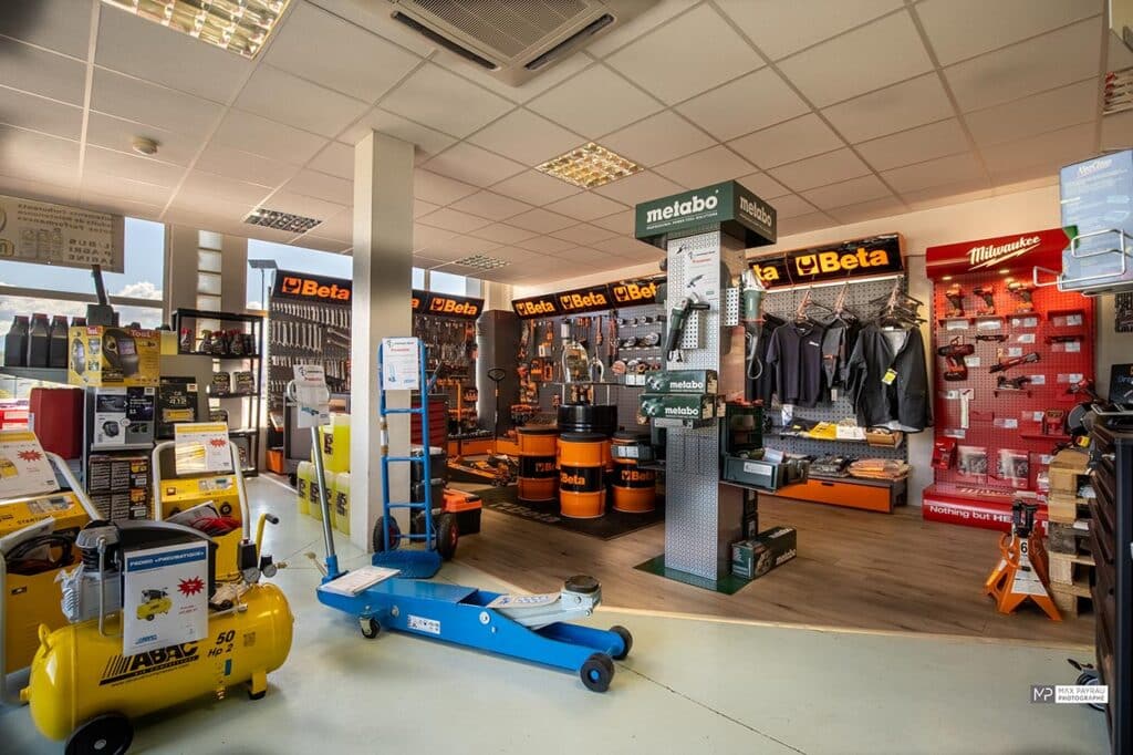 Équipement d'Atelier : Outillage Beta, Metabo et Milwaukee Showroom d'outillage professionnel avec marques Beta, Metabo et Milwaukee, compresseur ABAC et cric hydraulique bleu.